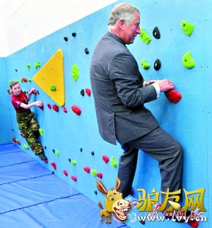 查尔斯身着正装与学生们一起玩攀岩。